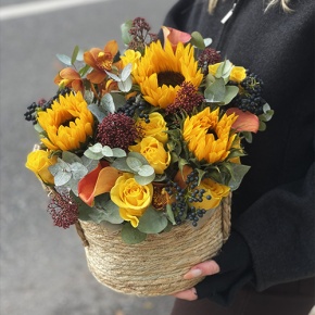 Композиция в сумке "Тональность" из подсолнухов, калл, ягод вибирнума, лимонных роз, скиммии и орхидеи в Люберцах